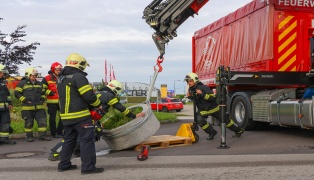 Kreisverkehr in Wels-Lichtenegg von LKW-Sattelzug unbeabsichtigt mit schwerem Blumentrog dekoriert