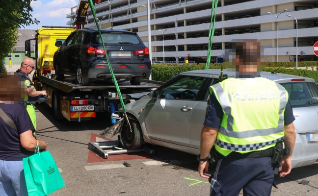Auto in Seitenlage: Crash zwischen zwei PKW bei Parkplatzausfahrt eines Einkaufszentrums in Pasching